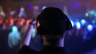Arkadan Görünüm. Arka ve ön planda, Dj kulaklık dans eden insanlar bulanık.
