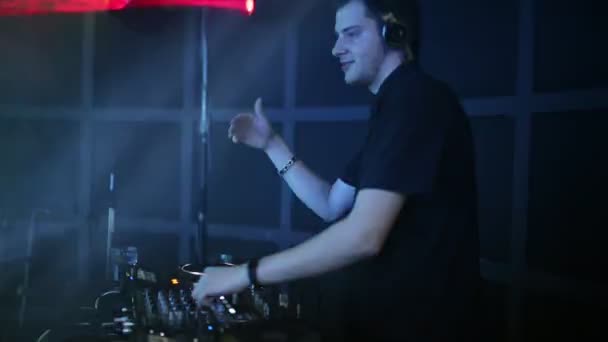 Profesionální Dj v klubu na večírku obrací dav lidí a mísí hudba. — Stock video