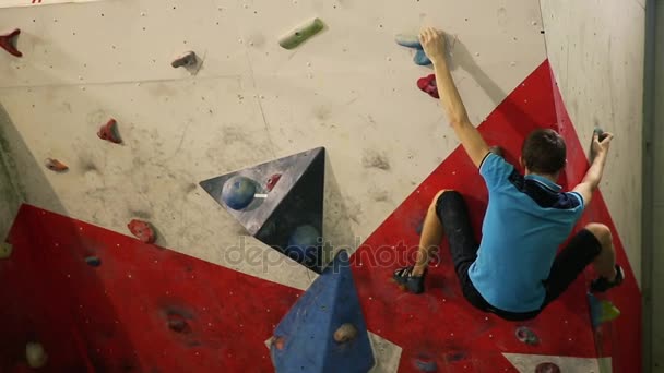 Ein Bergsteiger klettert eine steile Wand hinauf und bricht nach einem missglückten Aufstiegsversuch zusammen. — Stockvideo