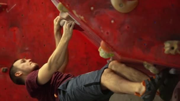 O alpinista está treinando para escalar uma montanha com um grande ângulo. Um atleta profissional. Totalmente pendurado acima do solo. Parede horizontal. Falha, caindo da parede . — Vídeo de Stock