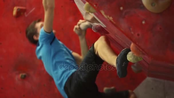 L'arrampicatore si sta allenando per scalare una montagna con un grande angolo. Un atleta professionista. tentativo fallito di superare l'ostacolo. Vista dal basso . — Video Stock