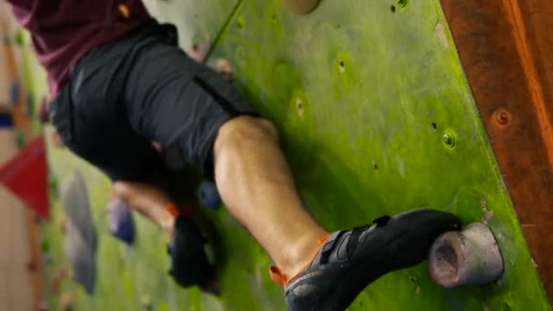 Detailní záběr na nohy horolezců na cvičná stěna pro horolezce. Pohled zdola — Stock video