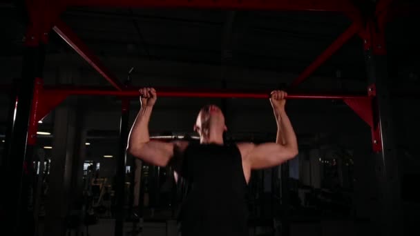 Stedikam mouvement de la caméra, un homme en tenue de sport noire tire sur la barre, puis va à squats avec un haltère avec un bar. formation circulaire . — Video