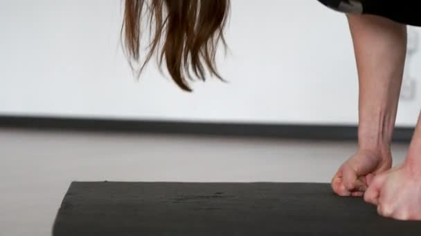 Close-up van een meisje doen push-ups en soepel gaat op haar handen, voert rekoefeningen en ontspannende haar terug spieren. De camera grimaces door de handen. — Stockvideo