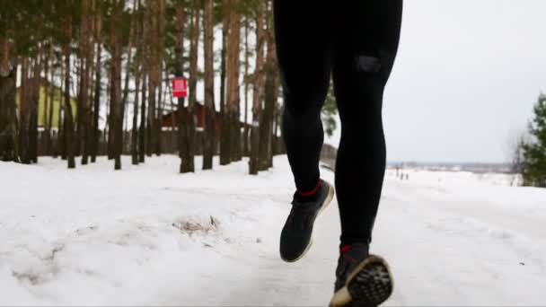 En ung man i en röd jacka går genom skogen i en bygel i casual kläder. Framifrån. Kamemra flyttar från idrottare fötterna till ansiktet. Slow motion. 120 bilder per sekund — Stockvideo