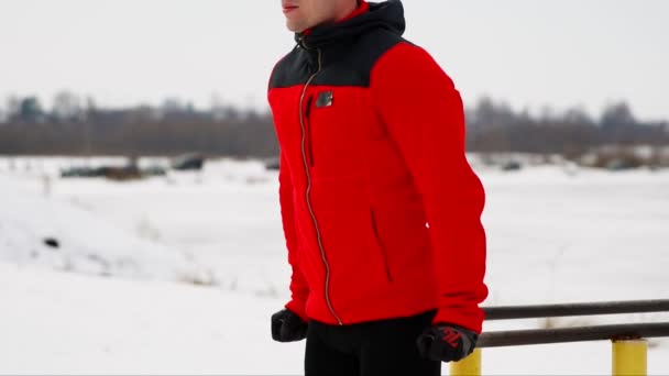 Un uomo addestrato allo sport esegue flessioni su sbarre parallele in inverno all'aria aperta. Primo piano — Video Stock