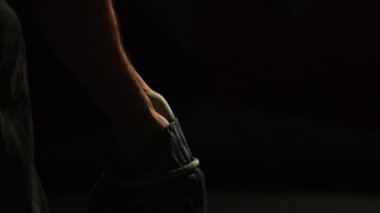 Balder profesyonel bir el ile siyah bir zemin üzerine yakın çekim. Tebeşir kaymasını karşı ellerini uygulayın. Pamuk ve toz farklı yönlere dağılmış. Spor yarışmaları. Arka ışık