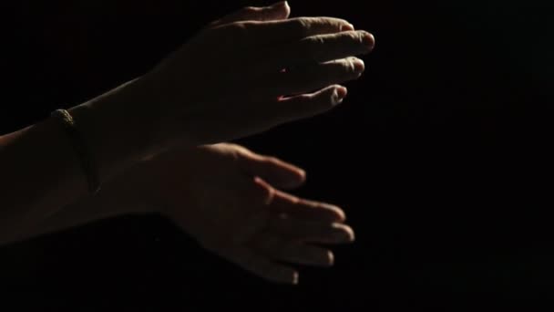 Close-up op de handen van een zwarte achtergrond van een professionele klimmer in magnesia katoen en stof vliegt in verschillende richtingen — Stockvideo