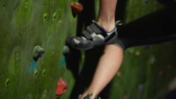 Close-up van voeten geschoeid in schoenen voor rotsklimmen overwinnen obstakels op de klimwand. Boulder — Stockvideo