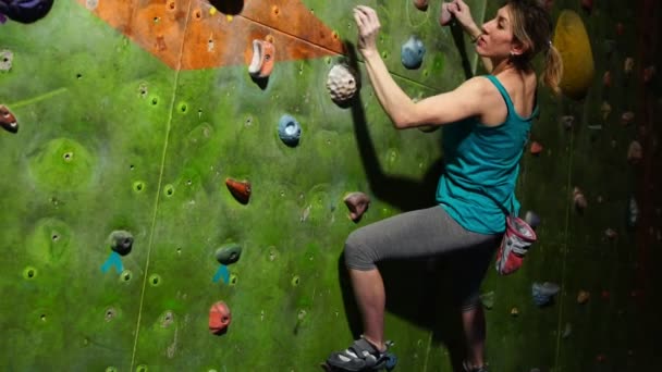Una roca femenina entrena para superar los obstáculos en la pared para los escaladores. Rescatador profesional. Muro de escalada. Movimiento lento — Vídeos de Stock