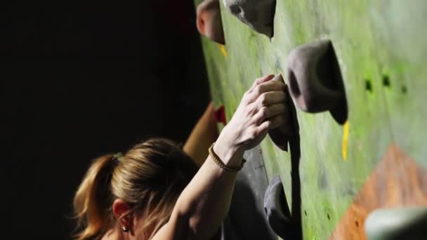 Gros plan de la main d'une grimpeuse qui grimpe sur le mur d'escalade le long du mur en trébuchant pour des compétitions sans assurance . — Video