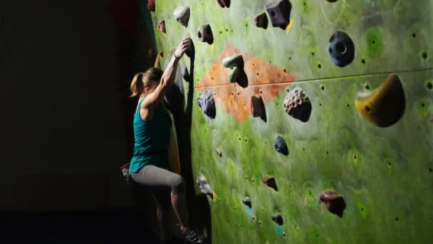 En kvinna klättrare är utbildad för att övervinna hinder på väggen för rock klättrare. Professionell räddare. Slow motion — Stockvideo