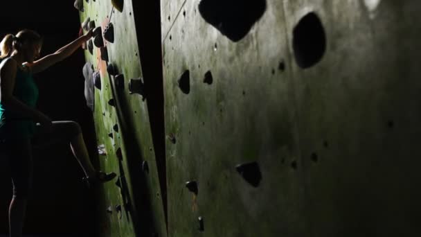 Close-up da mão de uma mulher alpinista que sobe na parede de escalada ao longo da parede tropeçando para competições sem seguro. Movimento lento. Loira — Vídeo de Stock