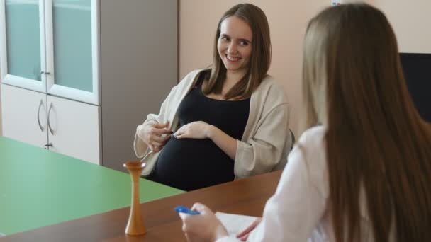 La paciente embarazada aprenderá los resultados de las pruebas de su médico. Una doctora da consejos sobre cómo prepararse para el parto — Vídeo de stock