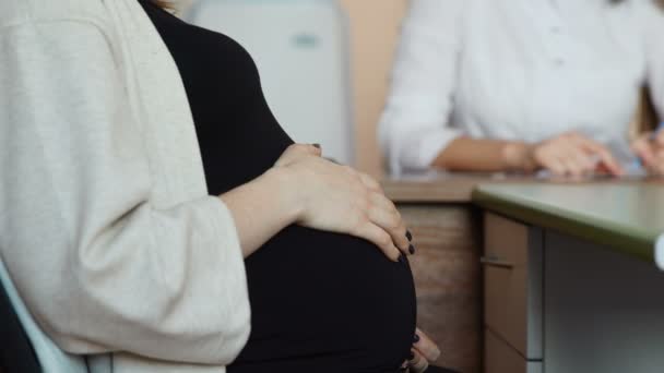 Die Ergebnisse der Tests erfährt die schwangere Patientin von ihrem Arzt. Eine Ärztin gibt Ratschläge zur Vorbereitung auf die Geburt. Die Arztpraxis befindet sich im Krankenhaus. glückliche Mutter. Kind in der — Stockvideo