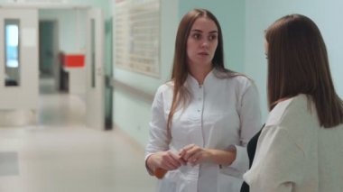 Organ nakli Merkezi koridorda duran bir hamile kadın beyaz bir sabahlık bir doktor ile iletişim kurar. Doğum için hazırlık. karnındaki bebeği.
