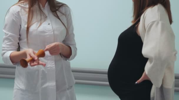 임신한 여자는 흰 드레싱 가운에 의사와 의사 소통 하는 이식 센터의 복도에서 산책. 출산에 대 한 준비입니다. 어린이 복 부입니다. 근접, 초상화. — 비디오