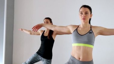 Ayak ve el Pilates yan alýþtýrmalarda simetrik iki güzel atletik genç kız dizlerinin üzerinde yetiştirilen.