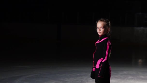 Професійний ковзаняр стоїть на льоду в ковзанах і дивиться прямо в камеру . — стокове відео