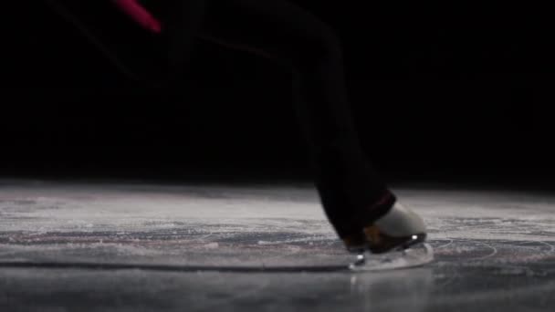 Gros plan, jambes en patins effectuer un saut et atterrir sur la glace. Fragments dispersés dans différents sitorons . — Video