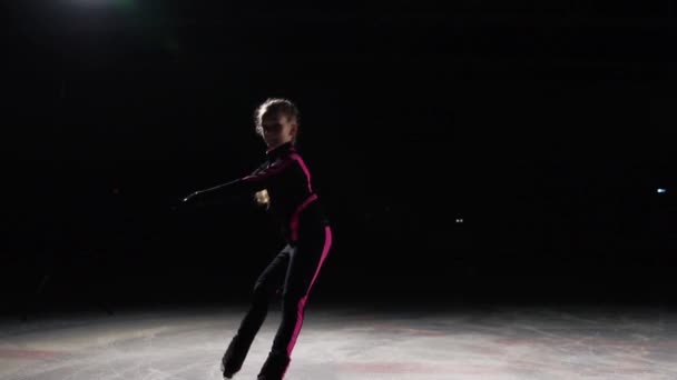 Professionell flicka skater flyttar isen på skridskor med ben ovikt åt sidorna. Kameran flyttas. Fördröjd skytte professionella skridskor. — Stockvideo