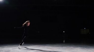Profesyonel bir kadın, buz pateni, yarışmalarda, siyah bir takım elbise için üç kişilik bir devrim olarak atlama kendi ekseni etrafında gerçekleştirir. Ve bir yay ile program sona erer.