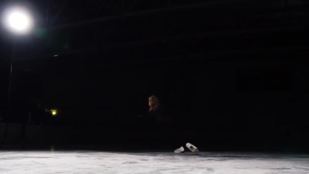 Eine professionelle Eiskunstläuferin läuft mit einer Drehung, um einen Kreisel mit ihrer Achse auf schwarzem Hintergrund zu drehen. — Stockvideo