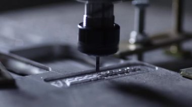 Robot çelik ile çalışmak için yazılan bir program yardımıyla şirket bir alüminyum plakadan bir tatbikat yavaş hareket ile kesilir. Metal talaşı sinek farklı yönlere.