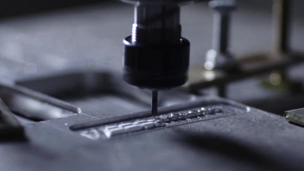 De robot in het bedrijf met behulp van een programma geschreven om te werken met staal is gesneden uit een aluminiumplaat met een boor in slow motion. Metalen krullen vliegen in verschillende richtingen. — Stockvideo