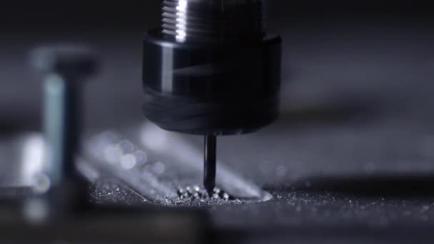 Le robot de l'entreprise à l'aide d'un programme écrit pour travailler avec de l'acier est coupé à partir d'une plaque d'aluminium avec une perceuse au ralenti. Les copeaux de métal volent dans différentes directions .