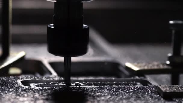 Le robot de l'entreprise à l'aide d'un programme écrit pour travailler avec de l'acier est coupé à partir d'une plaque d'aluminium avec une perceuse au ralenti. Les copeaux de métal volent dans différentes directions . — Video