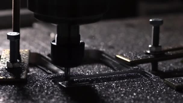 De robot in het bedrijf met behulp van een programma geschreven om te werken met staal is gesneden uit een aluminiumplaat met een boor in slow motion. Metalen krullen vliegen in verschillende richtingen. — Stockvideo