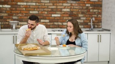 Pizza evde onların mutfakta yemek hamile kadın ve erkek. Fakir diyet. Yağlı gıdalar. Obezite