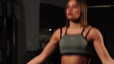 Spor, etkinlik. İp atlama ile sevimli bir kadın. Kaslı kadın siyah arka plan.