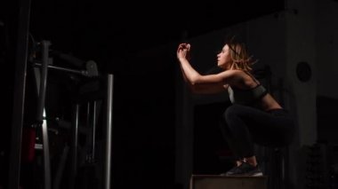 Gizli yüz ile en iyi ve kısa tayt giyen siyah spor karanlık bir spor salonunda kutusunu atlar güzel kadın fitness atlet gerçekleştirir