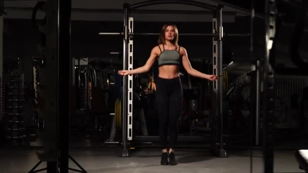 Deporte, actividad. Mujer linda con saltar la cuerda. Muscular mujer negro fondo . — Vídeos de Stock