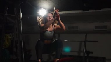 Gizli yüz ile en iyi ve kısa tayt giyen siyah spor karanlık bir spor salonunda kutusunu atlar güzel kadın fitness atlet gerçekleştirir