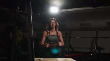 Gizli yüz ile en iyi ve kısa tayt giyen siyah spor karanlık bir spor salonunda kutusunu atlar güzel kadın fitness atlet gerçekleştirir