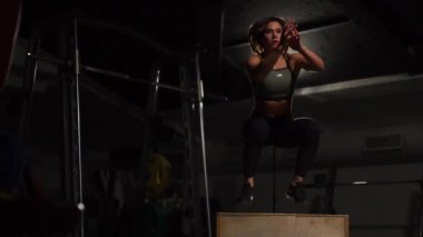 Gizli yüz ile en iyi ve kısa tayt giyen siyah spor karanlık bir spor salonunda kutusunu atlar güzel kadın fitness atlet gerçekleştirir