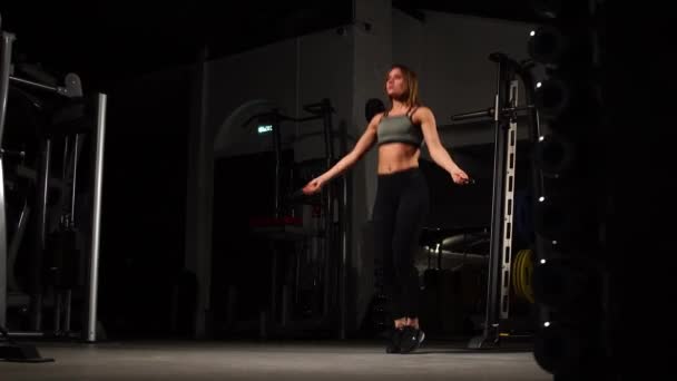 Sport, activité. Femme mignonne avec corde à sauter. Musclé femme fond noir . — Video