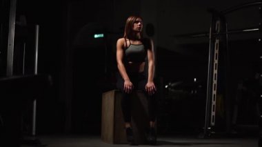 Gizli yüz ile en iyi ve kısa tayt giyen siyah spor karanlık bir spor salonunda kutusunu atlar güzel kadın fitness atlet gerçekleştirir