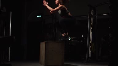 Gizli yüz ile en iyi ve kısa tayt giyen siyah spor karanlık bir spor salonunda kutusunu atlar güzel kadın fitness atlet gerçekleştirir