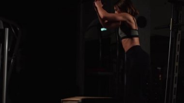 Gizli yüz ile en iyi ve kısa tayt giyen siyah spor karanlık bir spor salonunda kutusunu atlar güzel kadın fitness atlet gerçekleştirir