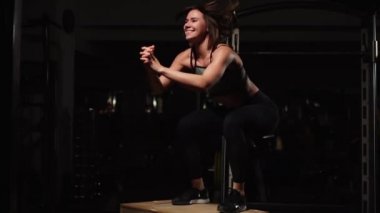 Gizli yüz ile en iyi ve kısa tayt giyen siyah spor karanlık bir spor salonunda kutusunu atlar güzel kadın fitness atlet gerçekleştirir