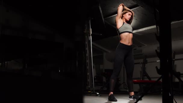 Mujer joven estirando los brazos antes de entrenar en el gimnasio . — Vídeos de Stock
