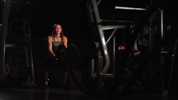 Athlète féminine travaillant avec des cordes lourdes à la salle de gym . — Video