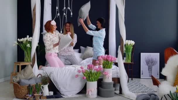 Trois jeunes femmes sexy se battant contre des oreillers lors d'une soirée pyjama en l'honneur du mariage. Belle femme riant et souriant ludique. Fête pyjama . — Video