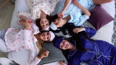 Dört gülümseyen kadın pijama yatağa yalan ve bir Pijama partisinde doğrudan kameraya bak. nedime. Bekarlığa veda