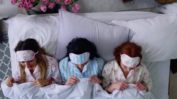 Vista superior, tres hermosas chicas se van a la cama y se ponen vendajes para dormir después de la noche de despedida de soltera y una gran fiesta . — Vídeos de Stock