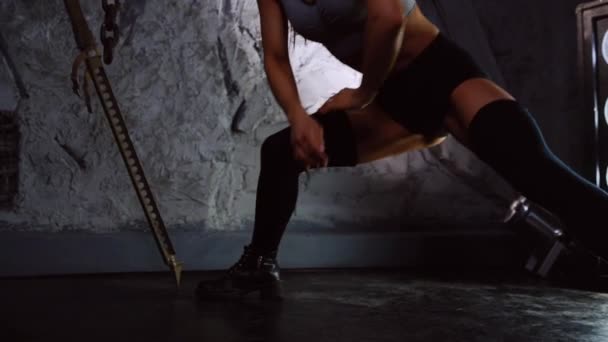 Brutális sport lány csinál a zömök, egyik lábát, a zuhatag. Alsólábszár- és combsúlyokat edzés közelről — Stock videók
